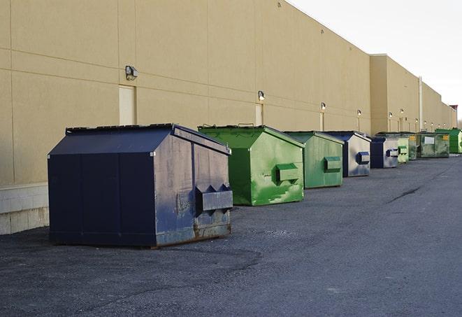 a pile of demolition waste sits beside a dumpster in a parking lot in Beverly Hills, MI